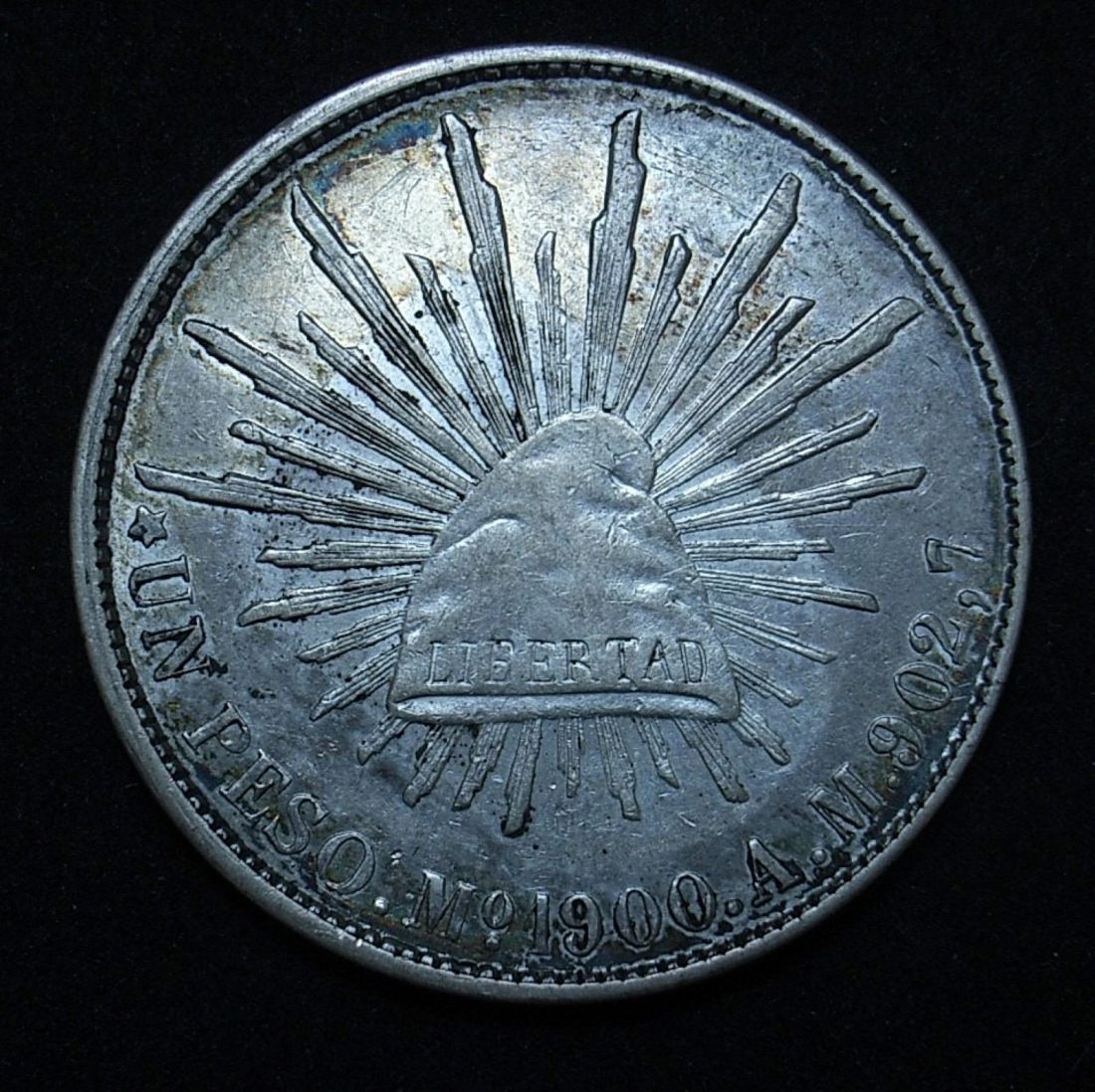 Mexican 1900 AM peso obverse close up, different light angle showing the coin's detail and lustre