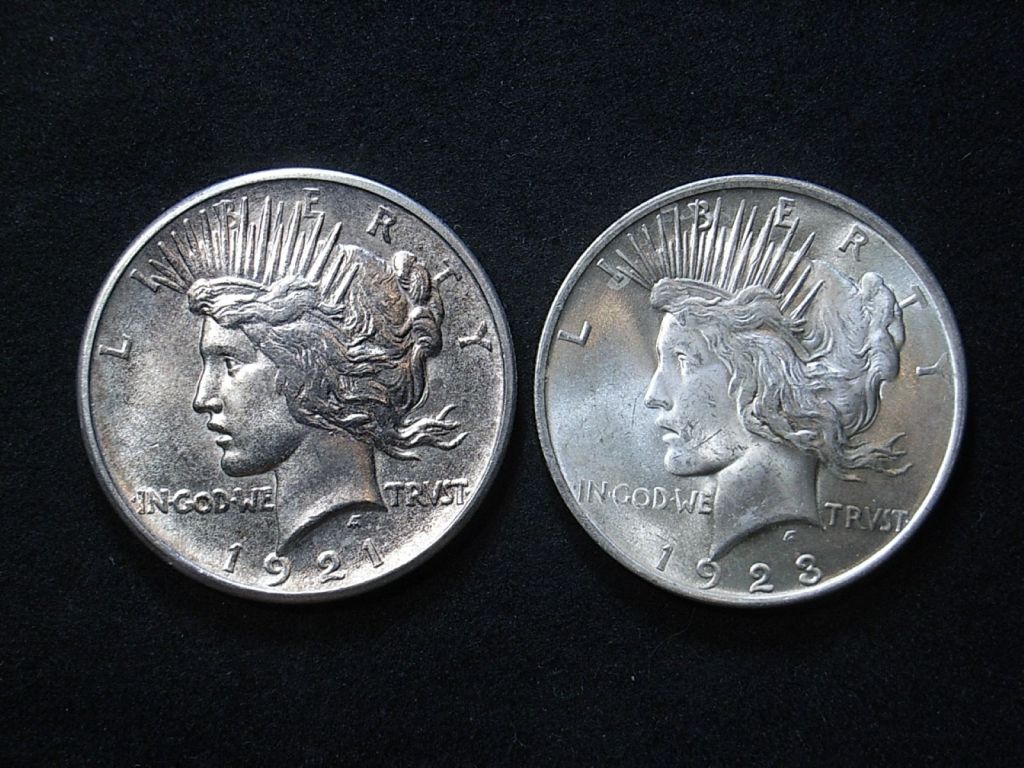 Close up comparison of relief on US 1921 vs 1923 Peace dollar obverse, highlighting detail on the coins